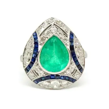 Un anillo con una esmeralda en forma de pera en el centro.