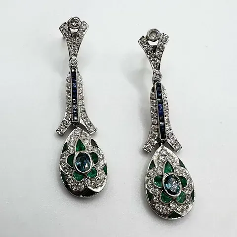Un par de pendientes con esmeraldas, zafiros y diamantes.