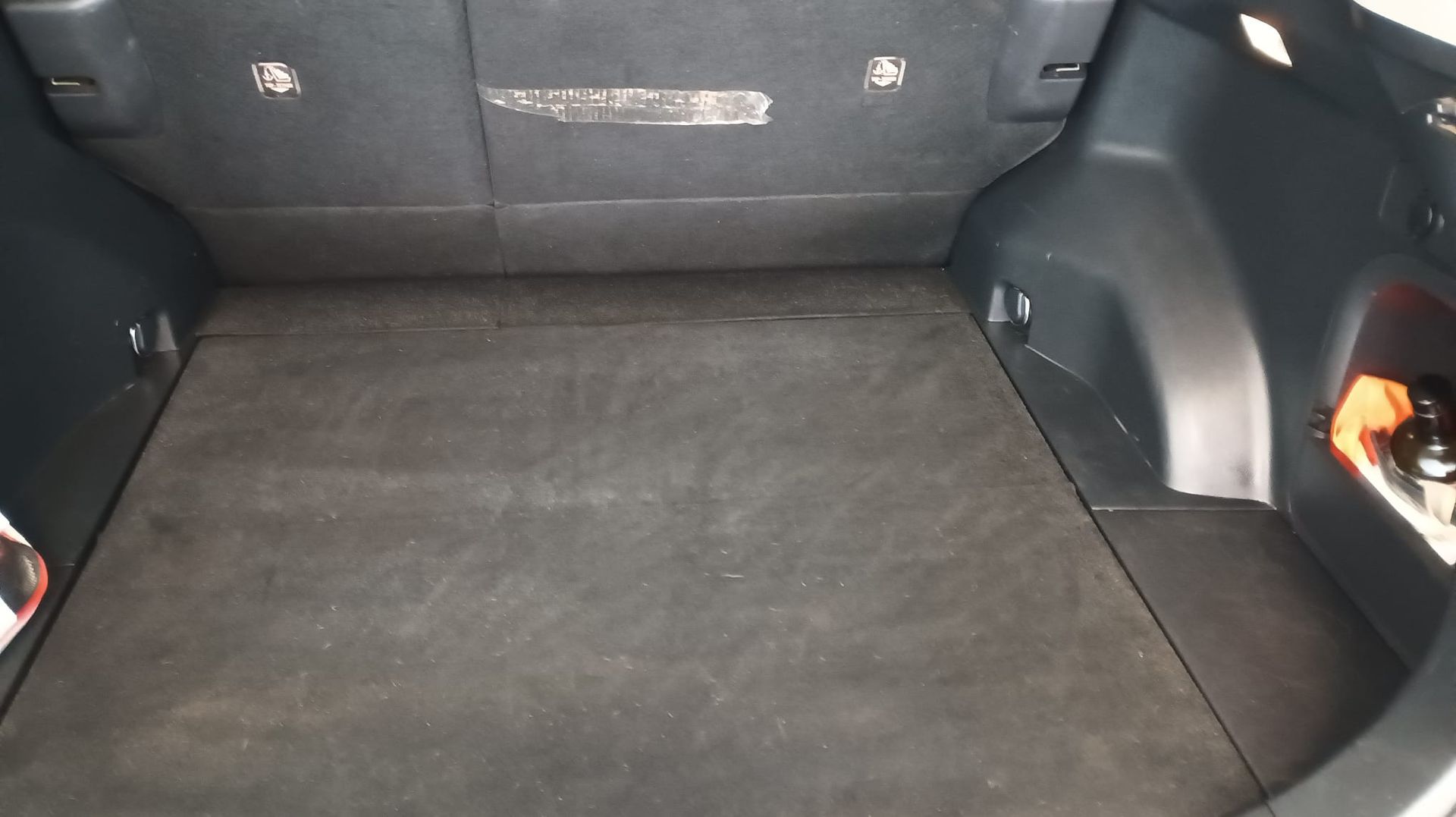 Una persona está limpiando una alfombra con una aspiradora.