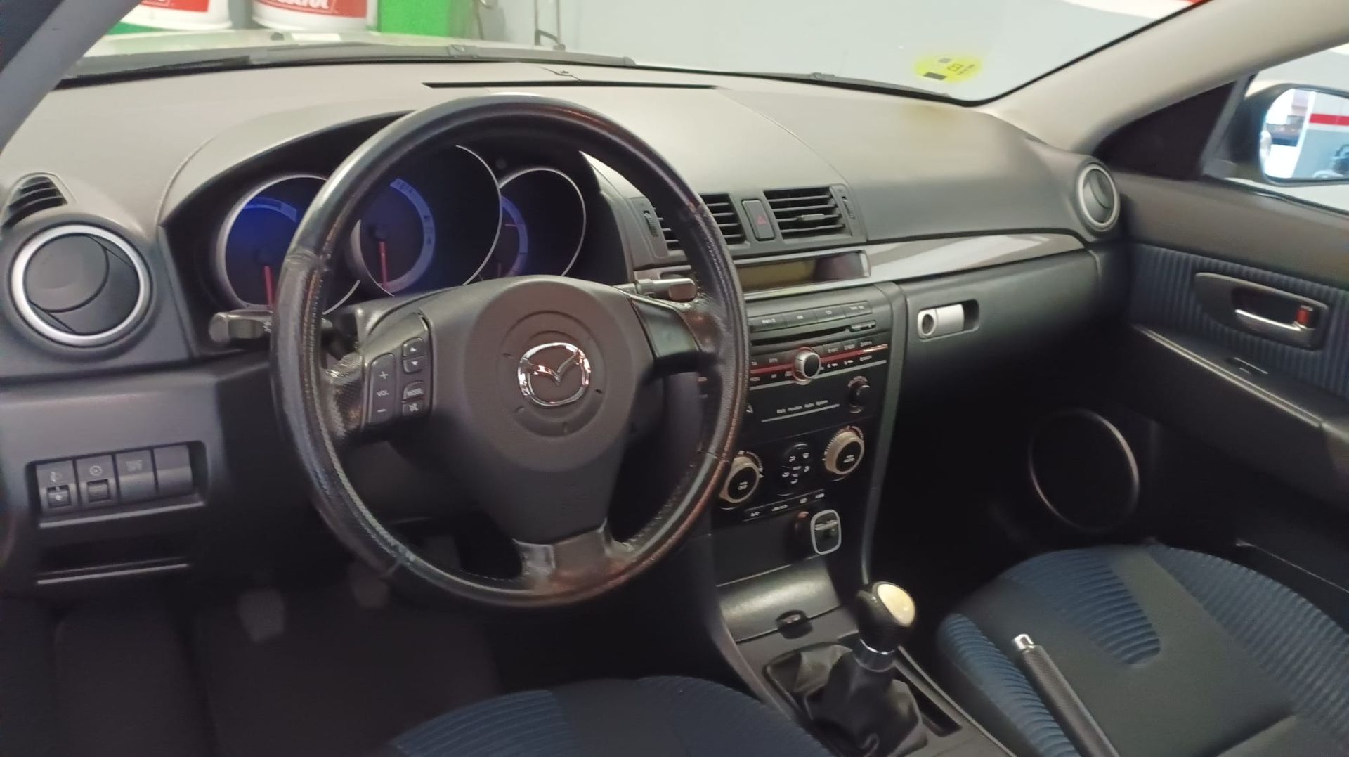 Un hombre está comprobando el nivel de aceite del motor de un automóvil.