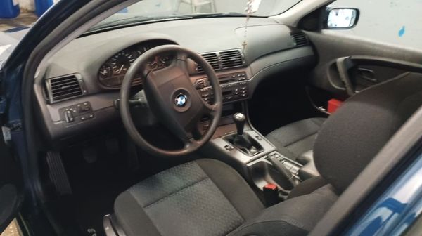 Un hombre está trabajando en el motor de un automóvil con una llave inglesa.