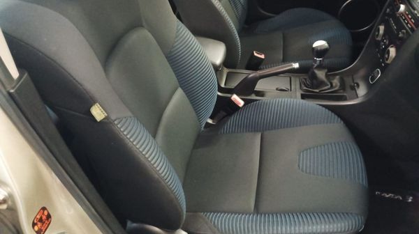 Una persona está arreglando un disco de freno de un coche con un destornillador.