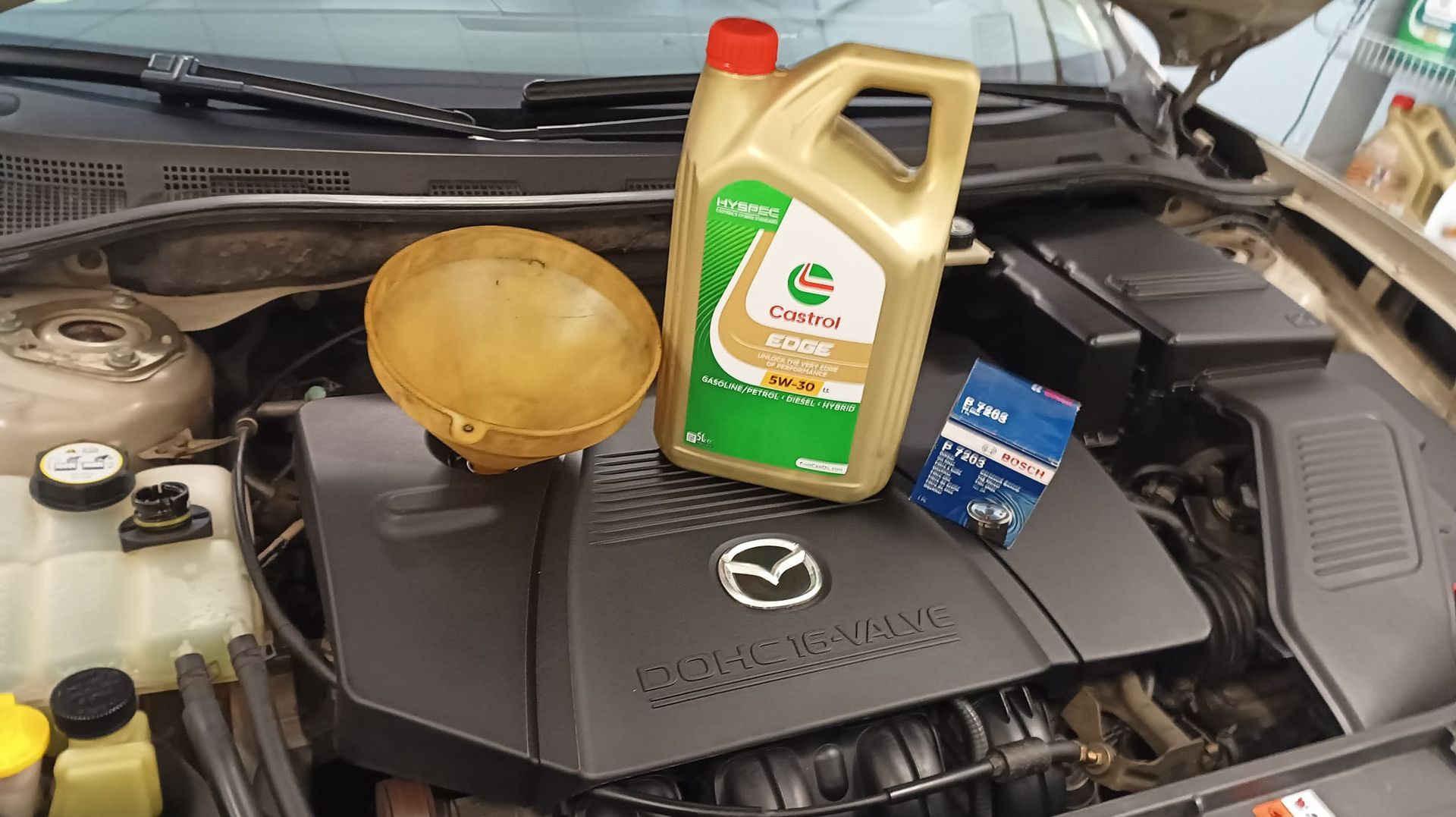 Un hombre está comprobando el aceite de un coche con una varilla de nivel.