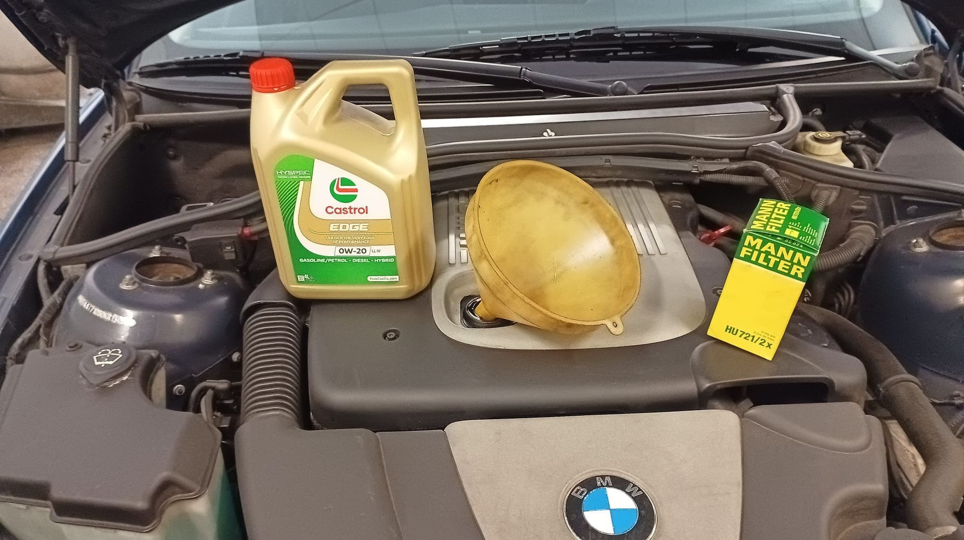 Una persona está vertiendo aceite en el motor de un automóvil.