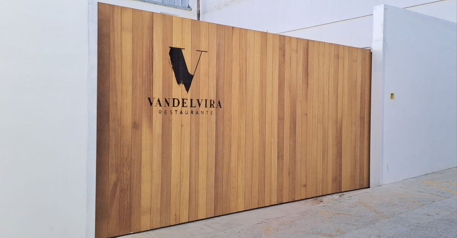Una puerta con paneles de madera, con el logotipo negro y el texto 