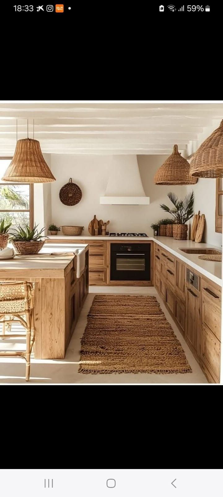 Una cocina rústica de estilo mediterráneo con armarios de madera natural, paredes blancas y lámparas colgantes tejidas sobre una isla.
