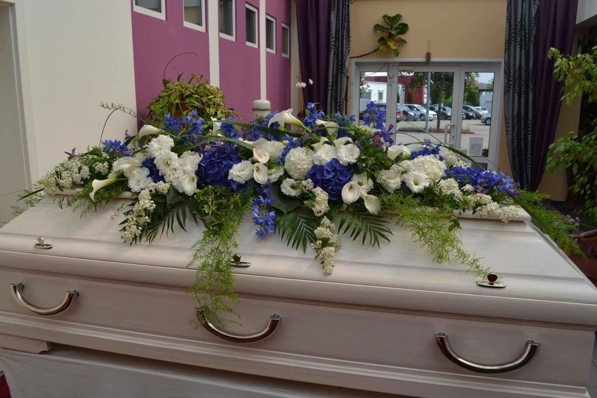 Blumengesteck auf einem Sarg.