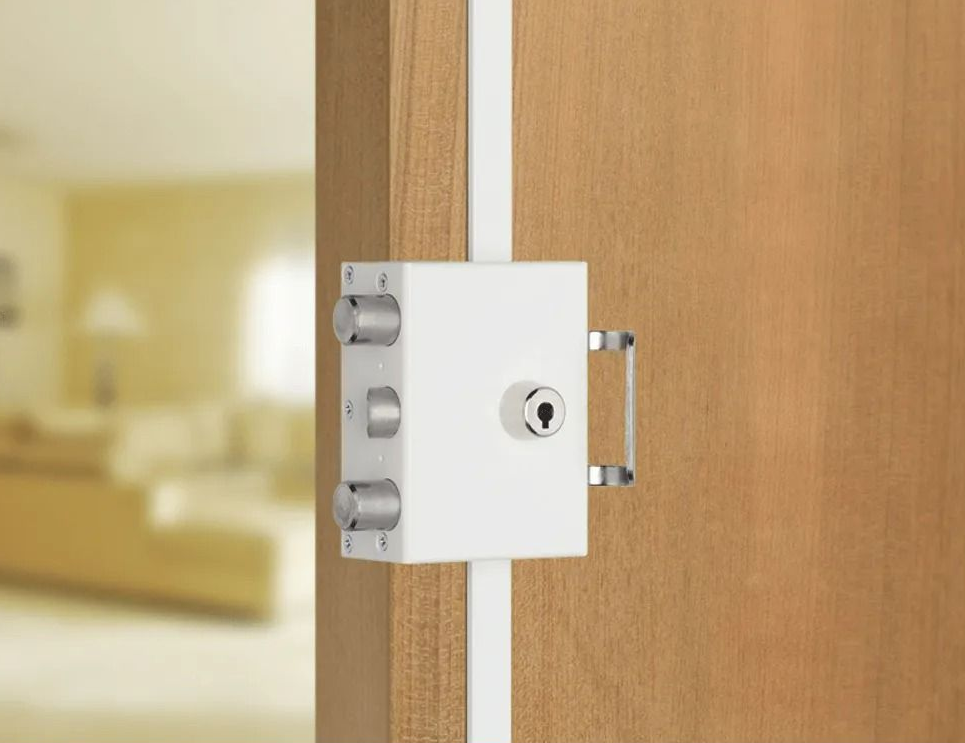 Serrure trident blanche sur une porte marron clair