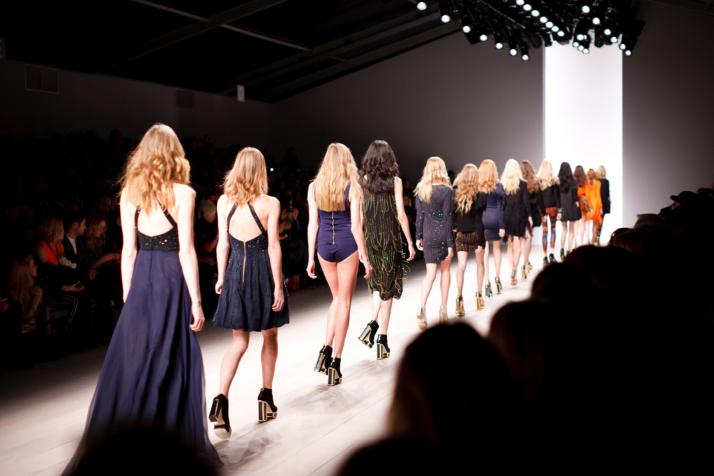 Un grupo de mujeres camina por una pasarela en un desfile de moda.