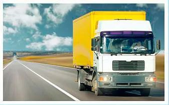 Un camión blanco con un remolque amarillo circula por una autopista.