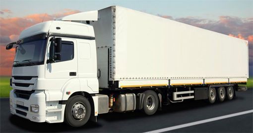 Un camión semirremolque blanco circula por una autopista.