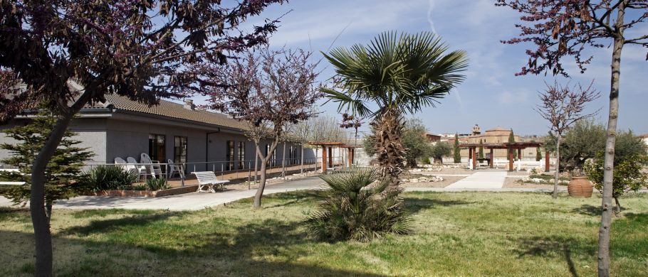 Una casa con muchos árboles al frente.