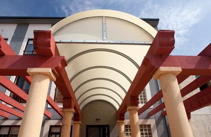 Un edificio con columnas y un dosel sobre la entrada.