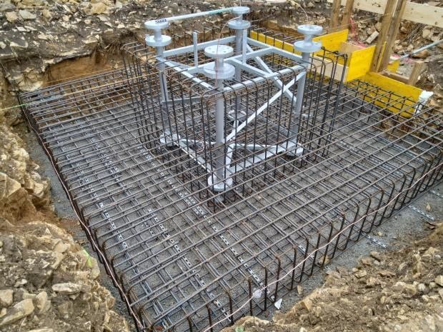 Zwei hohe Antennen auf einem Dach mit Blick auf die Stadtlandschaft bei bewölktem Himmel.