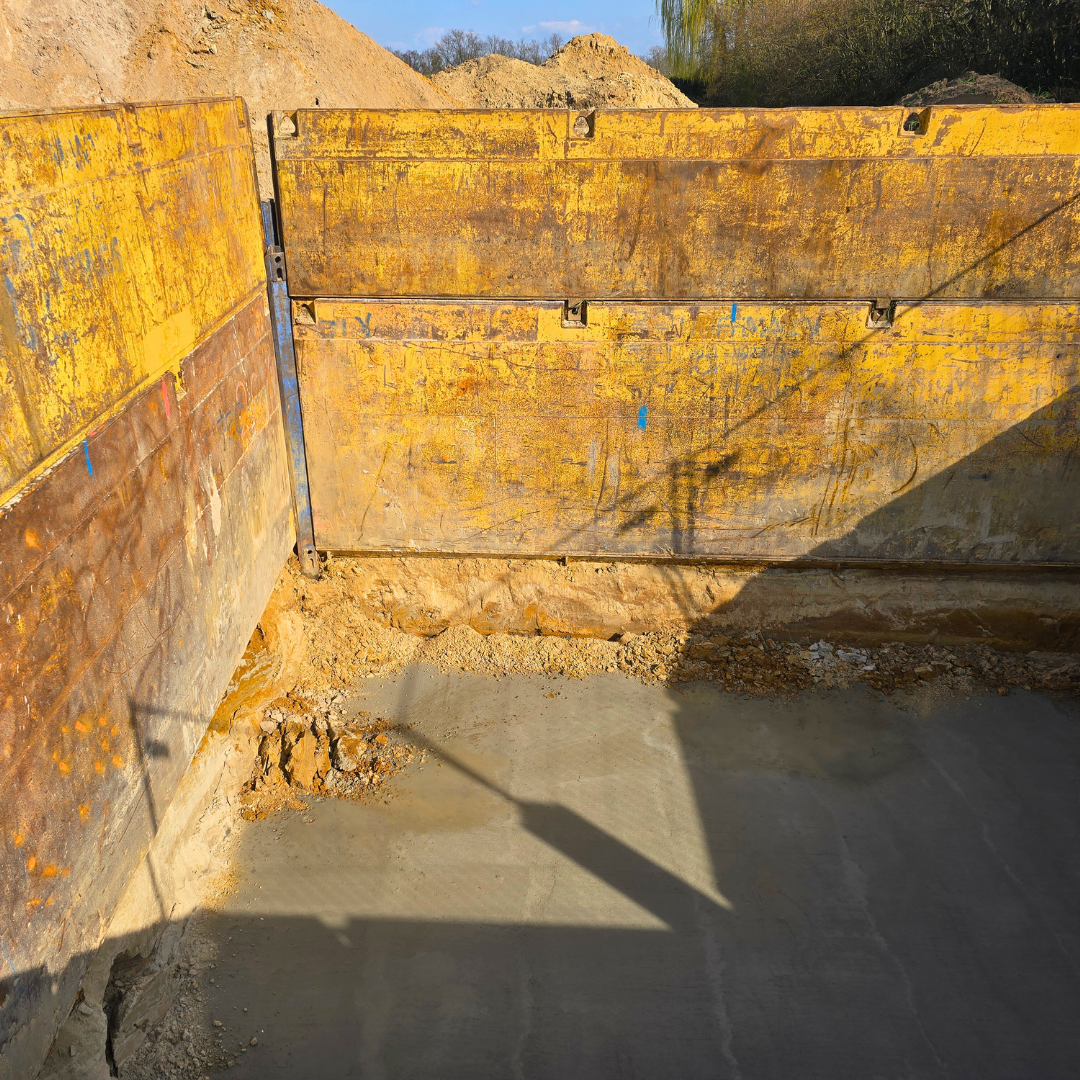 Das Innere eines gelben Müllcontainers mit einem Schatten auf dem Boden