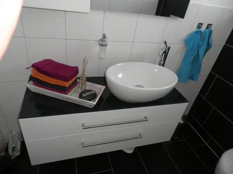 Ein Badezimmer mit Waschbecken und einem Tablett mit Handtüchern