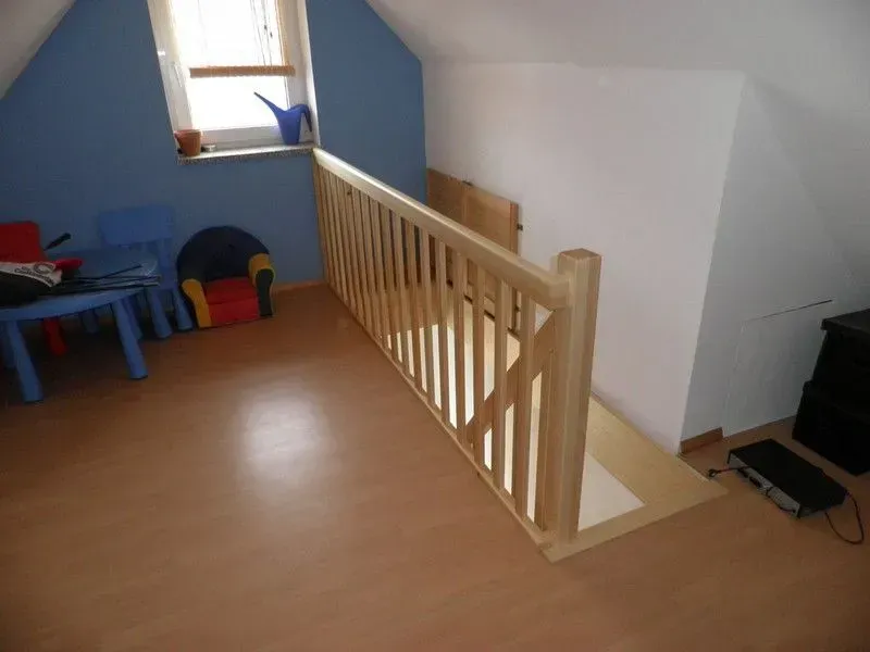 Eine Treppe mit Holzgeländer in einem Raum mit blauen Wänden