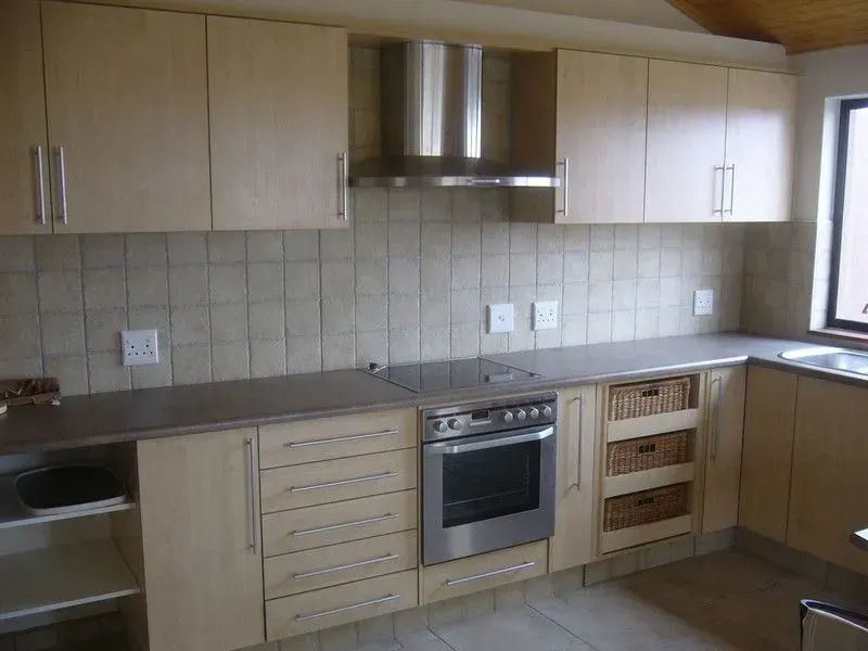Eine Küche mit Geräten aus Edelstahl und Holzschränken