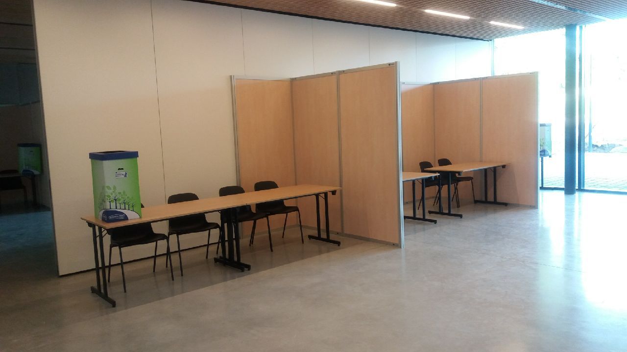 Espaces avec tables et chaises séparés par des cloisons.