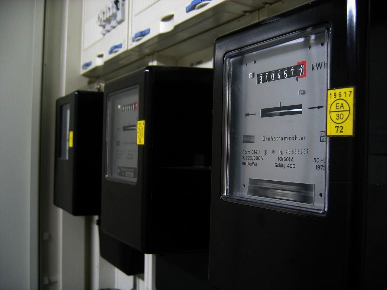 Una fila de medidores eléctricos negros con una etiqueta amarilla que dice 72.
