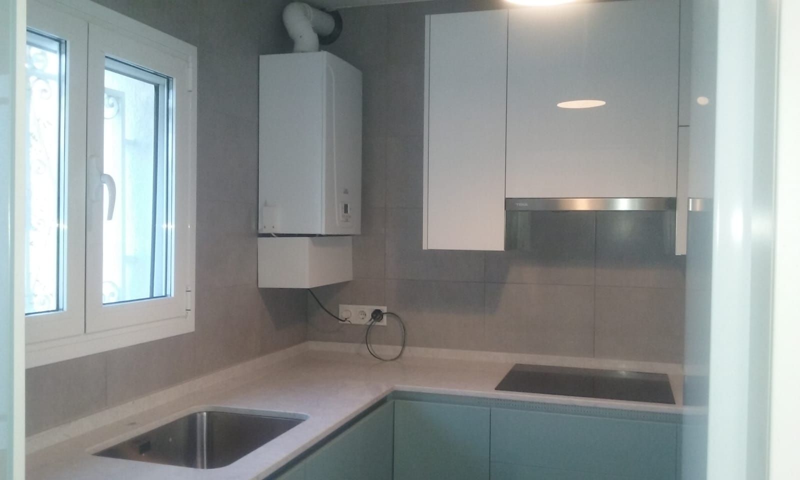 Una cocina con gabinetes blancos y un horno de estufa.