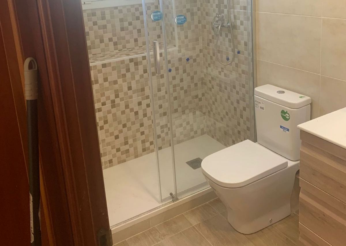 Un baño con inodoro, lavabo y ducha.