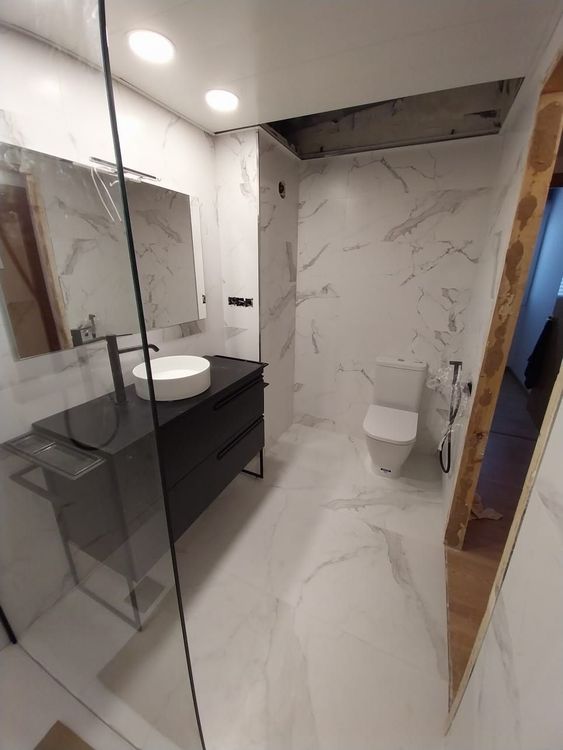 Un baño con lavabo, inodoro y espejo.