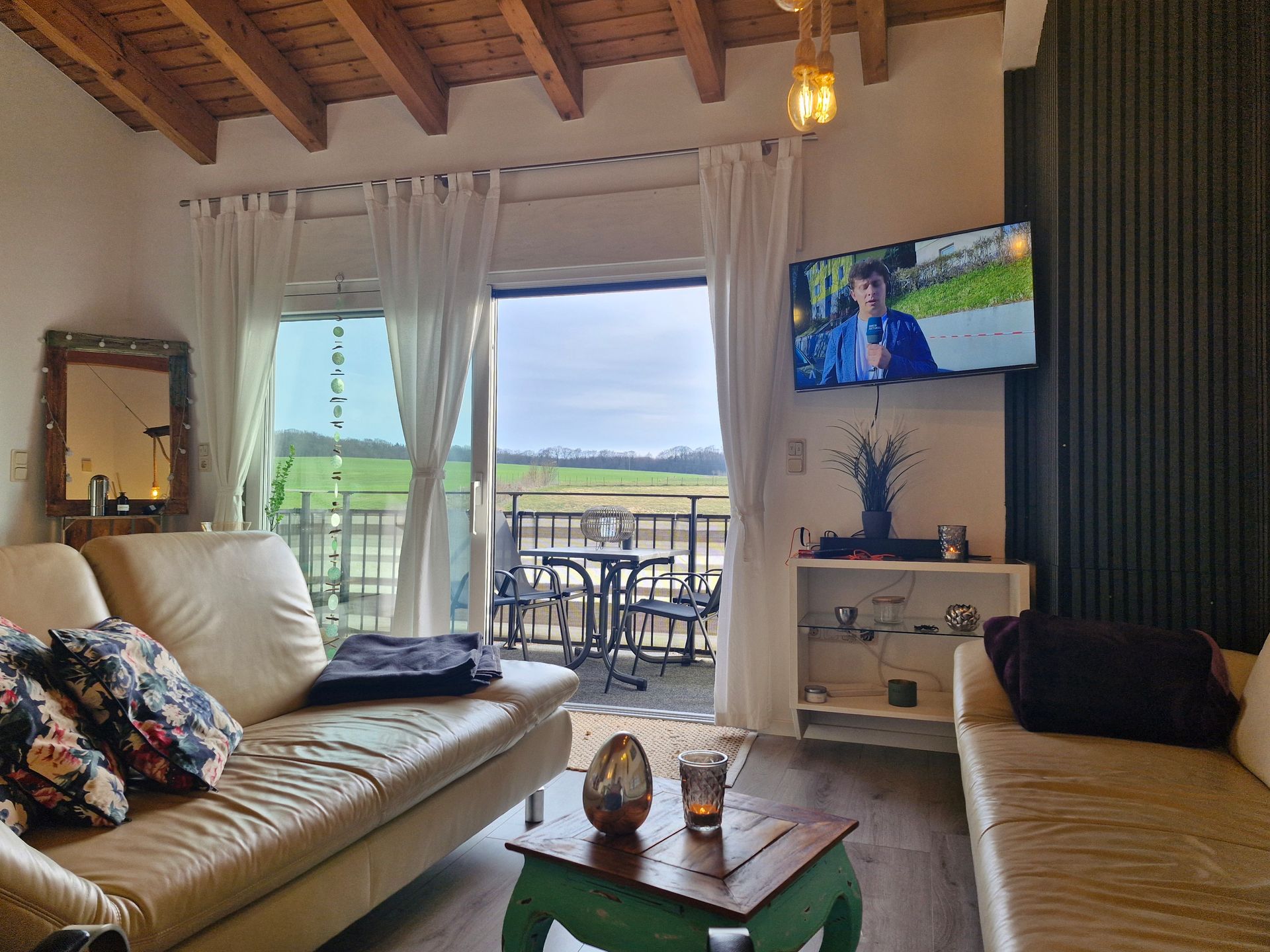 Ansicht Wohnzimmer mit Sitzecke und Zugang zum Balkon