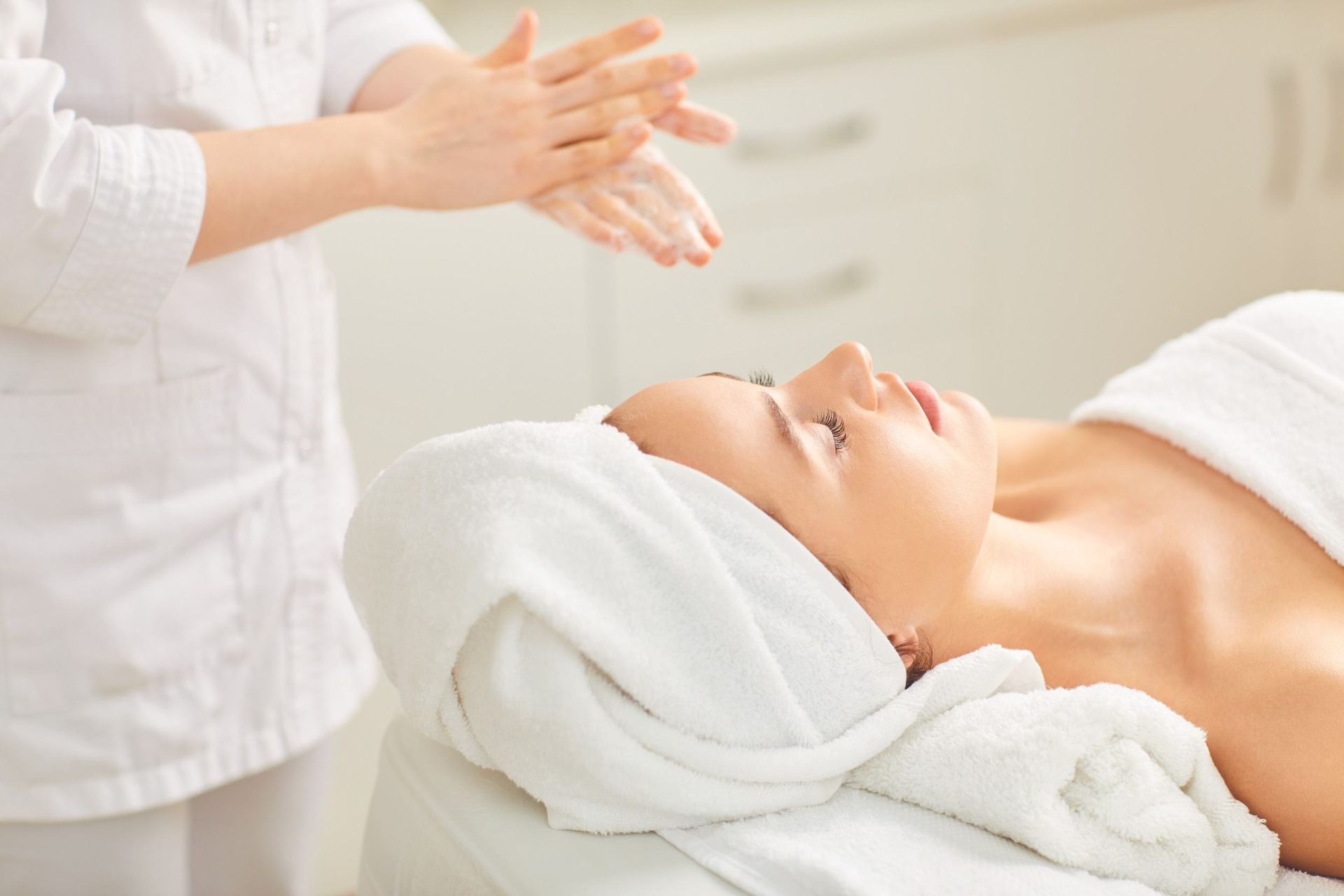 Una mujer está recibiendo un masaje en un spa con una toalla envuelta alrededor de su cabeza.