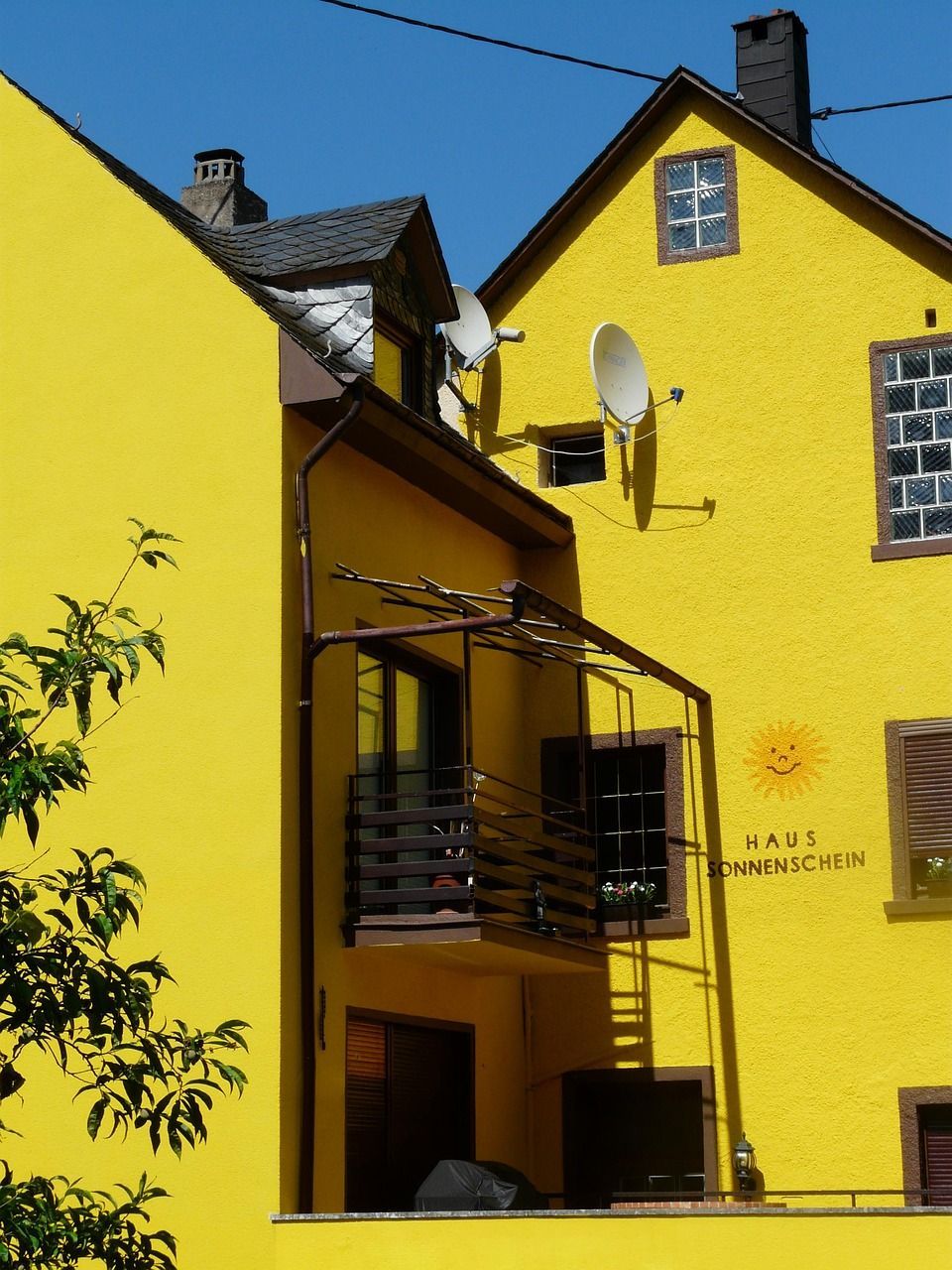 Maler streicht Hauswand mit Malerrolle