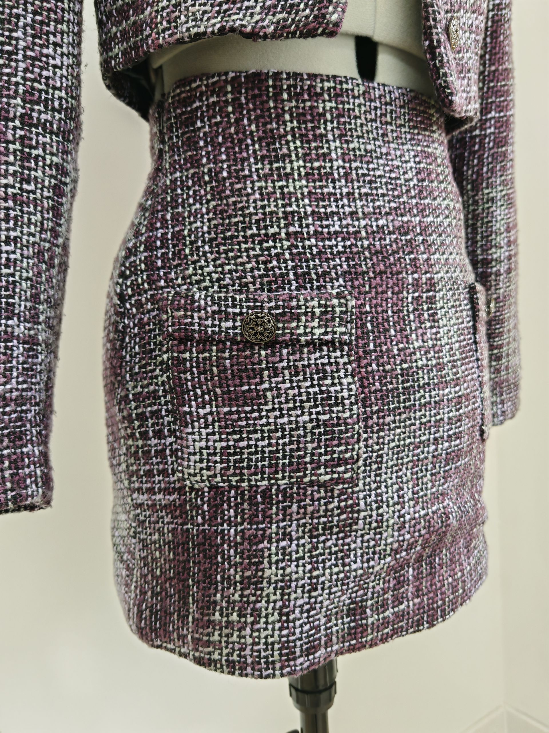 Jupe en tweed avec une poche avant, présentée sur un mannequin.