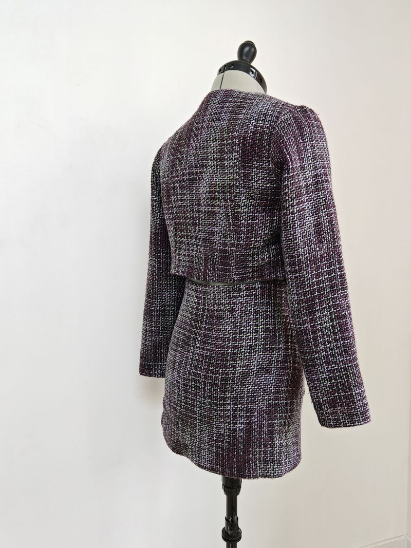 Manteau texturé sur un mannequin de couture.