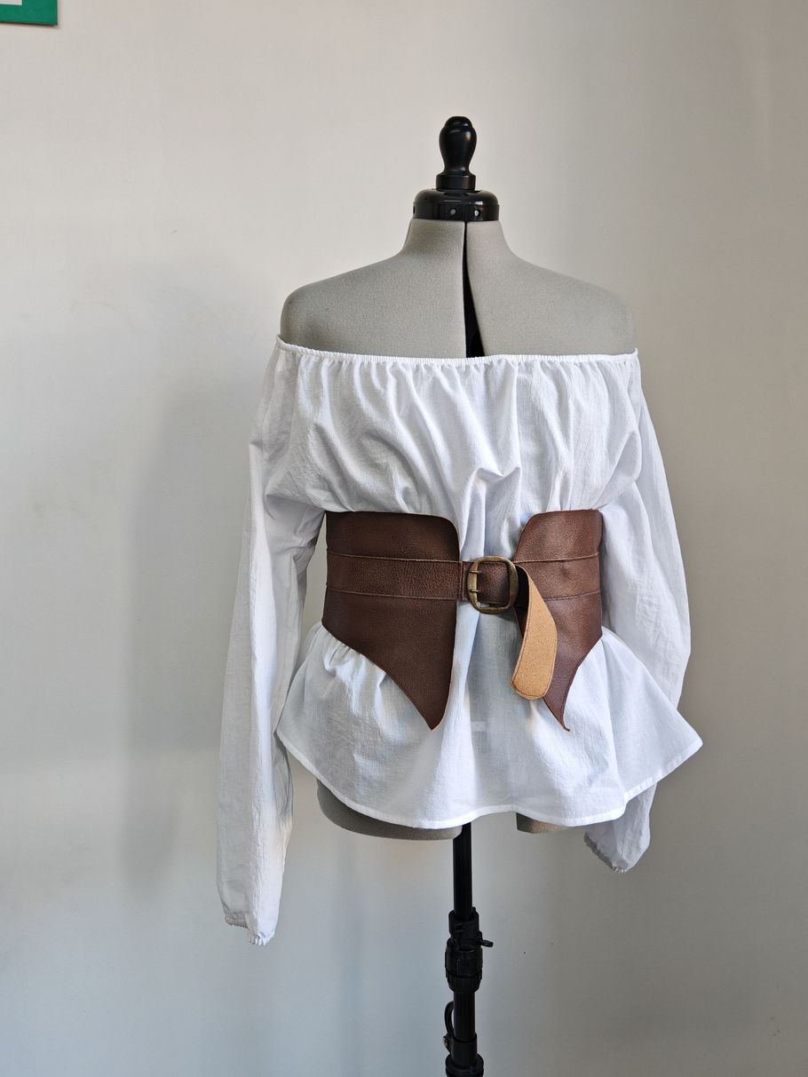 Chemisier à épaules dénudées avec une large ceinture corset sur un mannequin de couture.