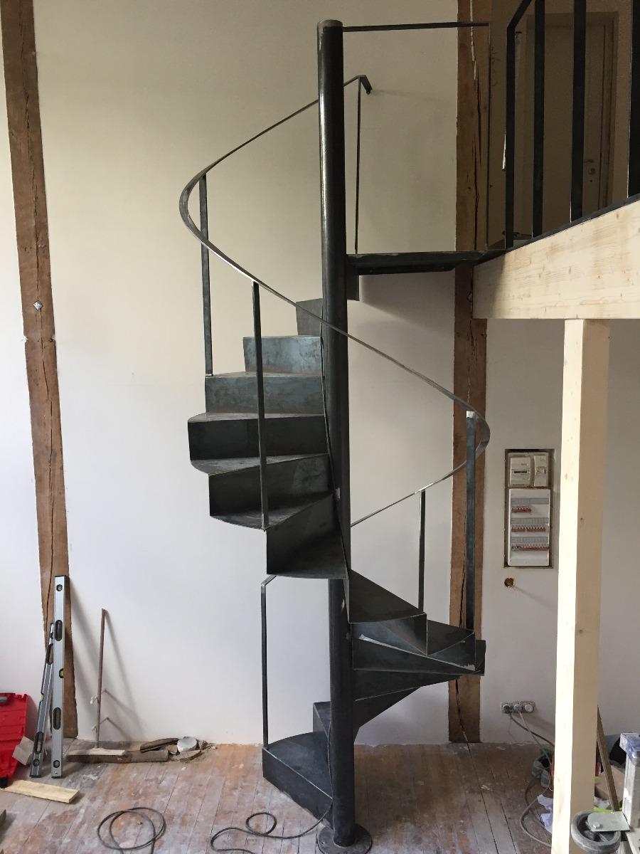 Escalier métallique hélicoïdal en acier brut dans un atelier d'artiste- photo prise le jour de la pose