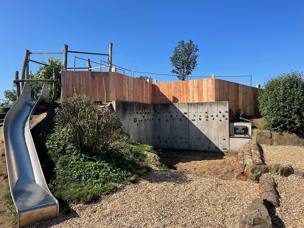 In der Mitte eines Spielplatzes steht eine Rutsche.