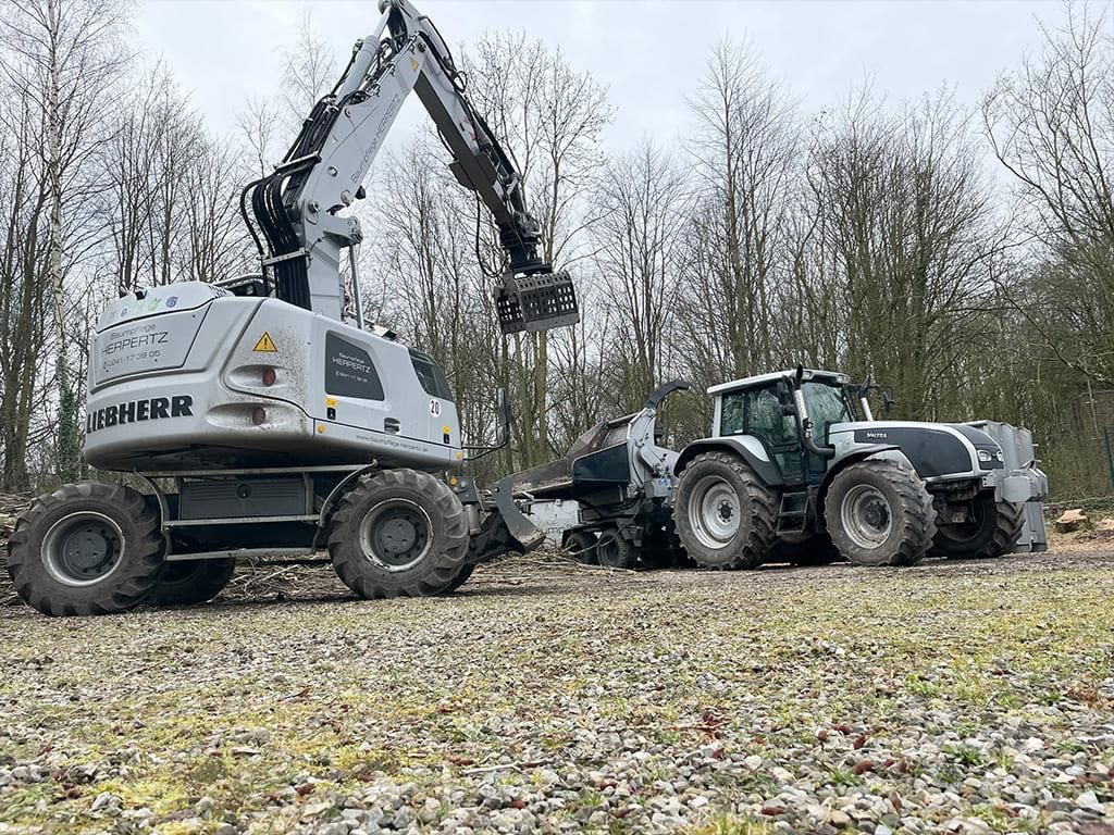 Auf einem Feld sind eine Planierraupe und ein Traktor geparkt.