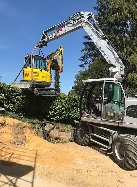 Mit einem großen Bagger wird ein Loch in den Boden gegraben.
