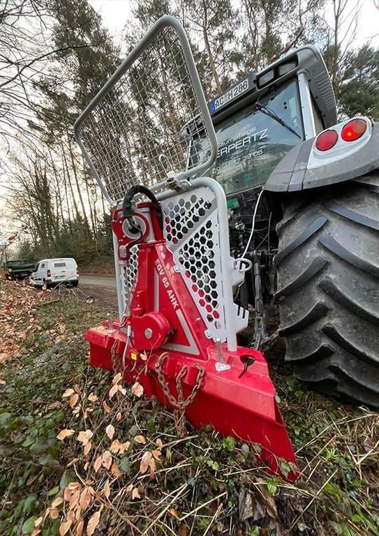 Ein rot-weißer Traktor steht auf einem Feld.