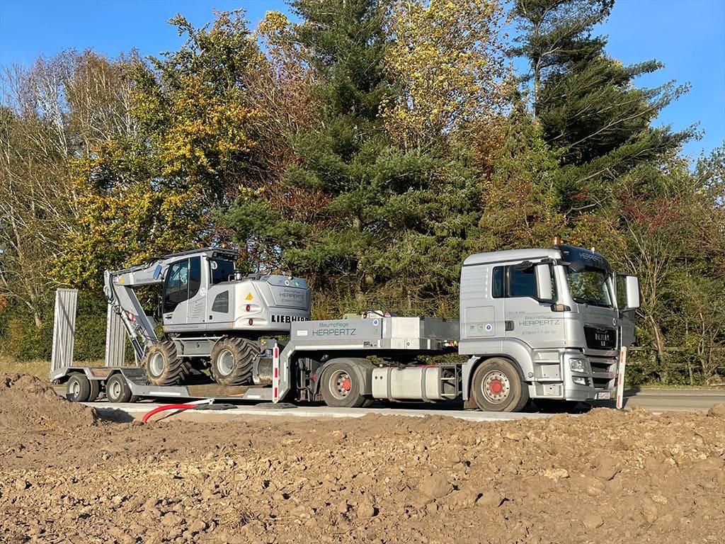 Auf einem Feld parken zwei Lastwagen nebeneinander.