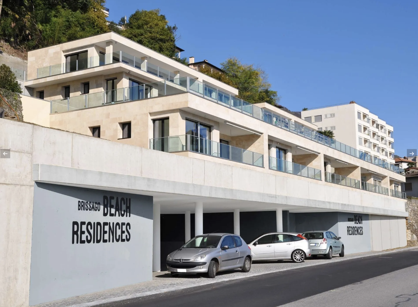 Moderno condominio, "Beach Residences", con parcheggio e balconi, situato sul pendio di una collina.