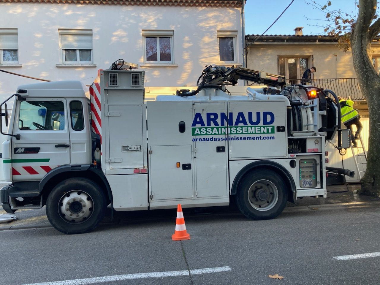 Camionnette utilitaire blanche stationnée à l'extérieur avec des machines montées sur sa benne.