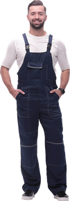 Un homme en salopette bleue sourit, les mains dans les poches.