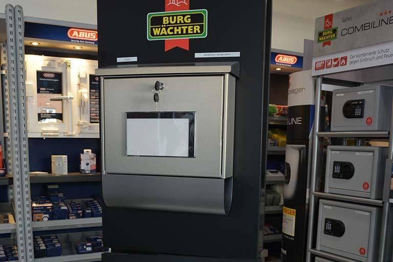 Ein Briefkasten aus Edelstahl in einem Geschäft mit der Aufschrift „Burg Wachter“