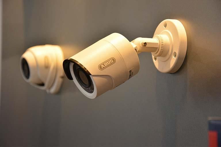 An einer Wand hängen zwei Überwachungskameras.