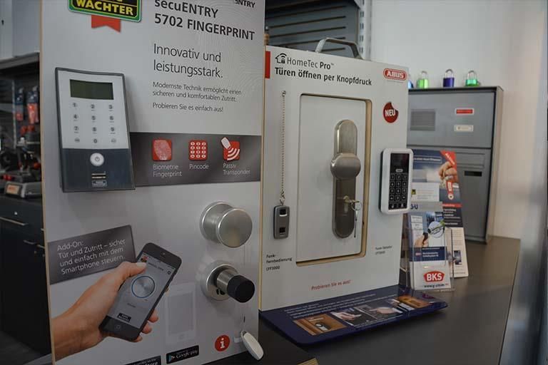 Eine Person hält ein Mobiltelefon vor einem Schild mit der Aufschrift „Wachtar“