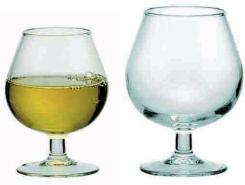 Dos copas de vino, una llena de vino y otra vacía, sobre un fondo blanco.