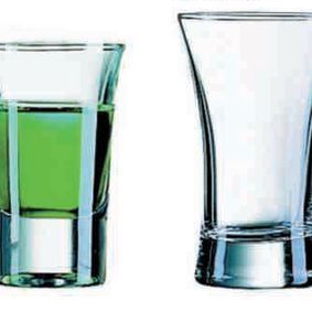 Dos vasos de chupito llenos de líquido verde sobre un fondo blanco.