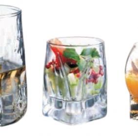 Tres vasos con diferentes tipos de comida en ellos sobre un fondo blanco.