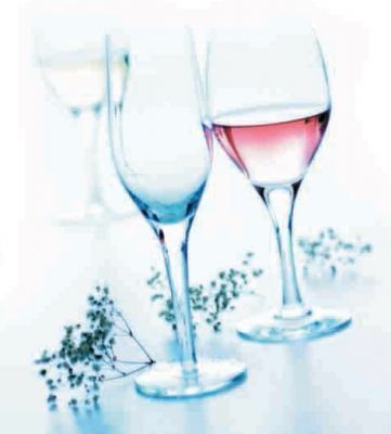 Tres copas de vino llenas de diferentes tipos de vino están sobre una mesa.