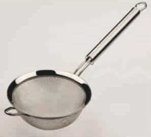 Un colador de acero inoxidable con mango largo sobre una superficie blanca.